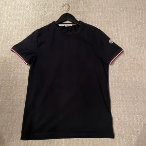 Moncler t-Shirt  - Säljer min moncler t-Shirt, den är i väldigt bra skick. Skick 9/10. Den ör i storlek M. Har kvitto och tags till den.  Hör gärna av dig om du har frågor! 