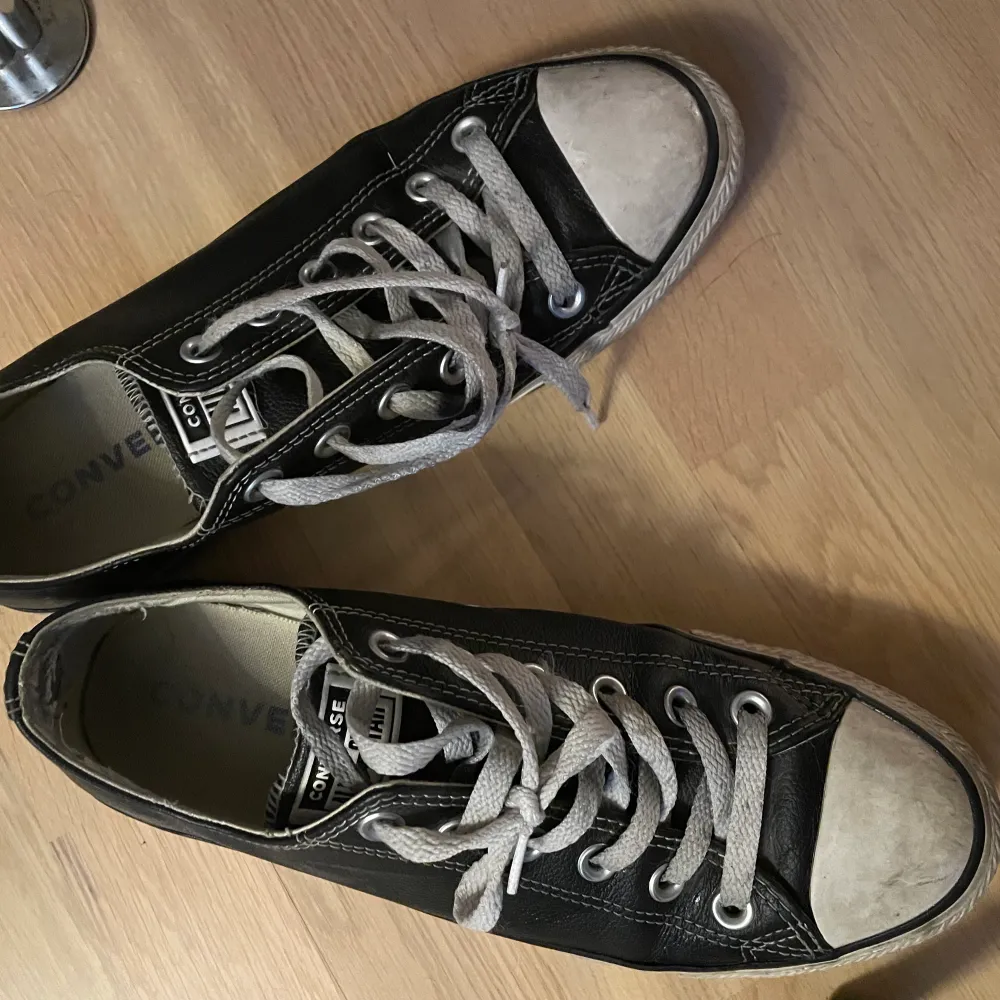 Låga Converse i svart läder. 6.5 men och 8.5 women i amerikans storlek. De har tyvärr traskat i blåbärsris, och ser därför ut som de gör. . Skor.