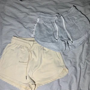 Grå shorts med text på sidorna där det står ”one of a kind” och beiga shorts utan tryck. - Färger: beige & grå