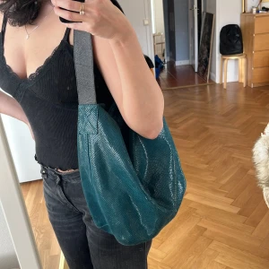 Väska ormskinnsimitation - Vintage väska ormskinnimitation som glittrar fint i ljuset. Mkt bra skick! Blågrön färg