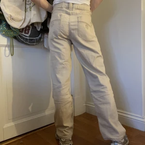 Beigea  - Beigea raka midwaisted byxor med broderade blommiga mönster på bakfickorna och ena framfickan 🐚 Byxor som fungerar till alla tillfällen!