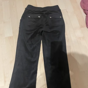 Juicy byxor - Svarta juicy byxor i använt skick! Fri frakt! Uppsydda så som på bilden! Passar för en person som är ca 155 cm lång max för att dom är uppsydda! Hoppas ni vill köpa❤️jag är 152 och dom är lite korta om man har dom högmidjade! Har bara tröttnat på färgen❤️❤️❤️