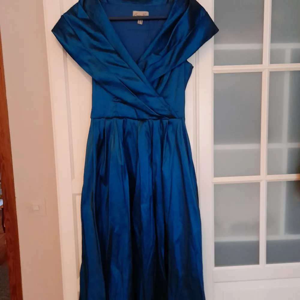 Vacker välsydd skimrande 50-tals festklänning från Lindybop, använd en gång. Vid kjol, tillhörande vid underkjol medföljer.. Klänningar.