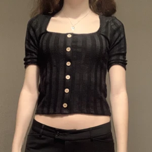 Svart topp - Säljer en svart topp från Stradivarius! Den är (typ) randig och har knappar, men den går ej att knäppa upp🥰