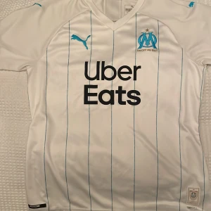Marseille tröja - Jag säljer min Marseille tröja för att den inte kommer till användning jag har köpt den för 900 kr i Dubai för några månader sen. Den är helt oanvänd bara provat den en gång. Kom privat för fler bilder. Köparen står för frakten.