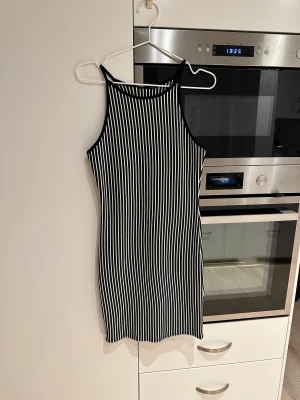 Svart vit randig klännning  -  Står storlek L men som storlek står står storlek L men är som 36-38. Stretchig tyg.  Fint skick.