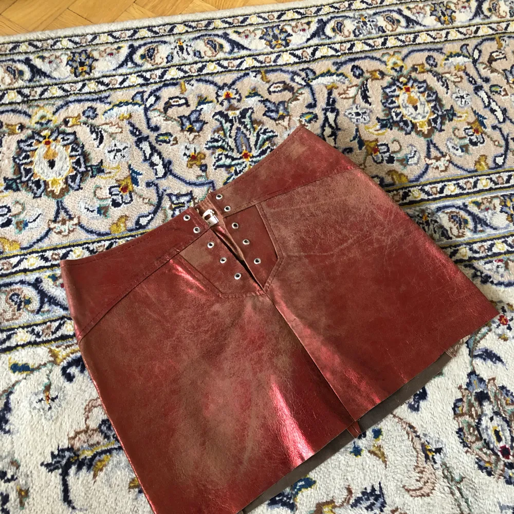 Skinnkjol från märket Le Complici i metalliska röd-bruna färger. Väldigt unik med snörning fram (eller bak?), low waist! Storlek M men funkar på S också ☺️<3. Kjolar.