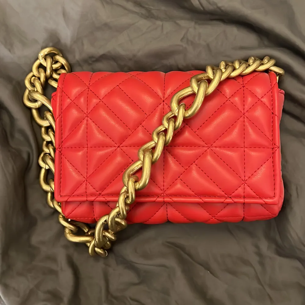 Säljer denna röda handväska från ZARA med stor guldkedja. Supersnygg väska men har tyvärr inte kommit till användning. Endast använd vid ett tillfälle. Nypris 299kr. Pris kan diskuteras vid snabb affär!. Väskor.