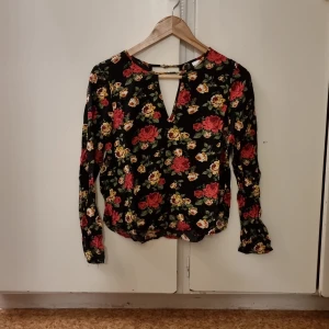 Blommig blus - Svart blommig blus använd en sommar