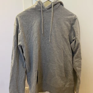 Grå hoodie utan tryck strl M - Enkel grå hoodie utan tryck, nästan aldrig använd men köpt för ett tag sen från lager 157! (Har inte kollat frakt än men det borde inte bli så dyrt)