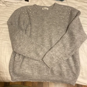Grå Stockholmstil tröja - jag säljer denna stickade tröja med pärlor på! den är i storlek 146/152 men passar också npgon som har M i kläder, som jag. Super skönt material och jätte stretchig. Vill bli av med kläderna så sätter den på ett billigt pris! Hör av er vid intresse💕💕