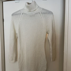 Vit stickad tröja med krage  - Lång modell Har en tajt passform 
