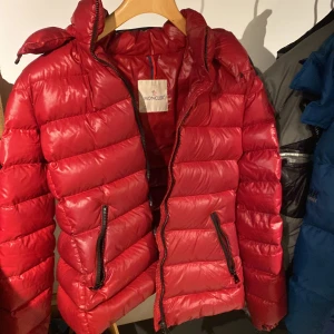 Moncler bady jacka - Moncler bady jacka i färgen röd, köpte den i slutet av 2019 och är använd endast fåtal gånger. Köptes på mytheresa, strlk 3. Den är varsamt använd och säljer då den är lite för liten.