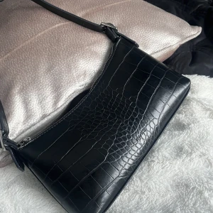 Orm väska - Säljer nu min orolig stiliga orm axelväska, köpt för 600 på NA-KD, säljer nu för 500. Den har både fack utan och med dragkedja inuti väskan vilket är positiv, är dock lite skadad under men inget man tänker på :)