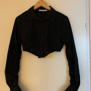 En kort svart skjorta från NA-KD, storlek 36. 