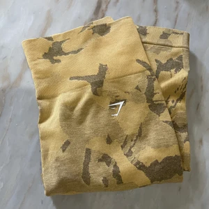 Gymshark adapt camo savanna  - Jag säljer mina gymshark adapt camo i färgen savanna då jag inte tyckte färgen passa på mig:/. Köpte dessa dyrt och har endast testat dom. Nypris 599kr jag säljer dessa för 300kr + frakt