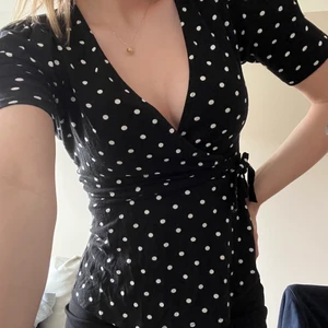 Prickig topp - Prickig topp från Gina Tricot i strl xs🤍🖤Har ett band runt midjan som går att knyta och ta av. Köpare står för frakt!