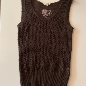 Brunt stickat linne  - Brunt stickat linne med blomm märken på. Använd mycket