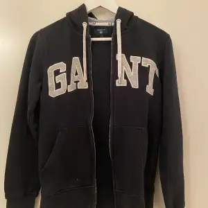 Säljer denna fina Gant zip up hoodie för 320kr. Den är i storlek XS och är svarta/mörkblå, pris kan förhandlas🤍 