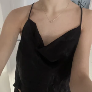 Topp från Zara - Snygg topp från Zara storlek S. Väldigt stor på mig som har XS. Ryggen är jättefin och öppen. Materialet är glansigt men visas inte riktigt på bild.