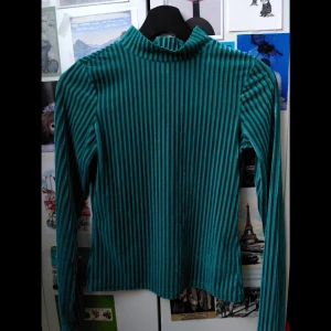 Grön polotröja monkie  - Lite festligare grön polo. Lite genomskinlig (sista bilden). Går att både klä upp och superfin på nyår men också att klä ner och bära till vardags. Storlek XS och bara använd ca 3 gånger. I mycket gott skick, ser iprincip oanvänd ut