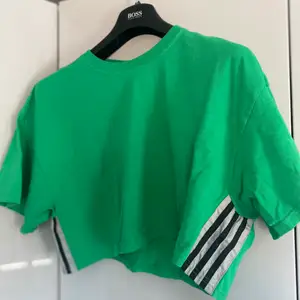 Grön croppad T-shirt med ”adidas” streck