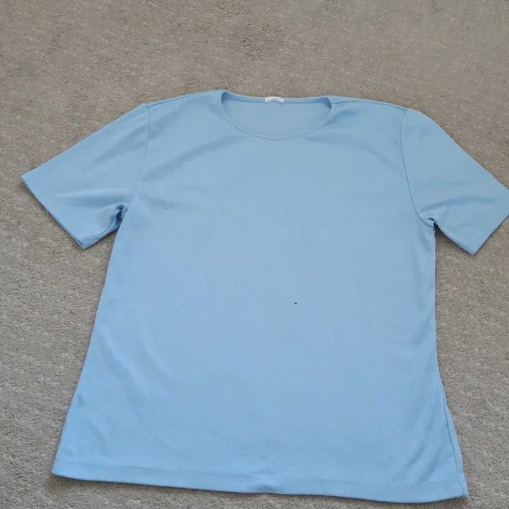 Ljusblå tröja, skulle säga att tröjan är en s/m.. T-shirts.