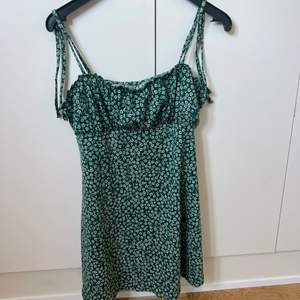 Grönblommig klänning från h&m i storlek M. Köptes för ca 2 år sen. Superfin klänning som man knyter uppe vid axlarna. 80kr+frakt