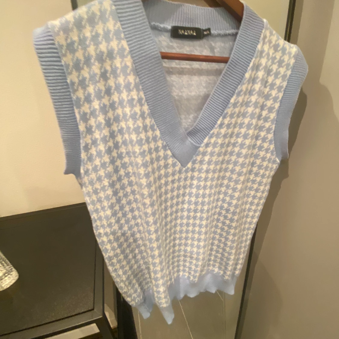 Blå stickad väst med hundtandsmönstrad 