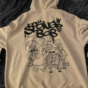 Hoddie - Säljer nu min favorit hoddie från hm. Finns ej kvar längre! Den är såå så cool. Den har ett tryck på ryggen där de är svamp Bob i svart och själva hoddie är bersh. Älskar den då den är overzized och super skön! Köpt för 300 säljer för 140