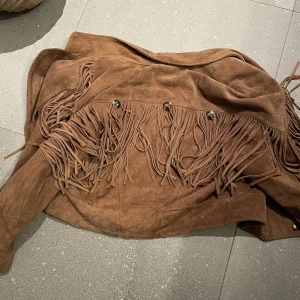 70-tal fransjacka i äkta mocka - Säljer nu min älskade vintage fransjacka i riktig 70-talsstil! Den är gjord av mocka, och den sitter riktigt snyggt på! Skulle uppskatta den som storlek M, sitter nice oversized på mig som är XS, och axlarna blir inte alls boxy 🥵