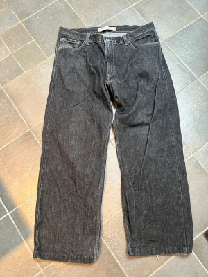 Levis 569  - I använt skick med slitage vid fötterna. Modellen är loose/straight och är ganska baggy på 