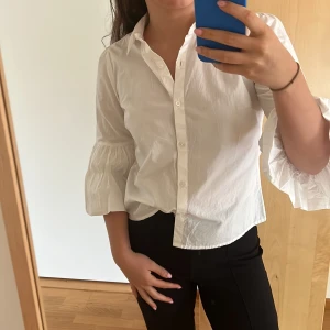 Vit skjorta med volang vid armarna - Super fin vit skjorta från Bikbok i storlek S med volgang ärmar!!!!🤍🤍🤍🤍 Bra skick då jag knappt använt den! Köparen står för frakt!!!