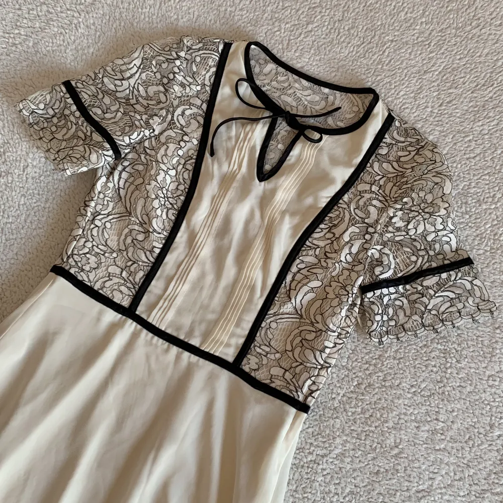 Superfin äggvit klänning från H&M med spets och svarta kontraster. Använd en gång.  I nyskick. 🌻 Perfekt klänning inför våren och sommaren 🌻. Klänningar.