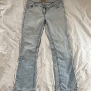 Fina ljusa jeans med rosa sömmar. Flare i modellen. Midjemått: 86cm innerbensmått: 83cm Rise: 23cm. Hör av er vid frågor!