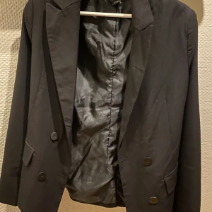 Kavaj - Svart kavaj som är stängbar med två knappar fram. Fickor finns och den är storlek 34. Skriv om du vill ha bild på hur den sitter på💞