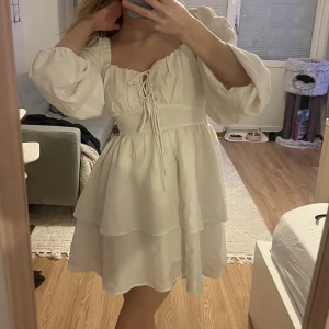 Vit klänning - Vit klänning med knytningar i fram och superfina volanger, perfekt till student eller avslutning🌸 Endast använd en gång☺️ord. pris 599
