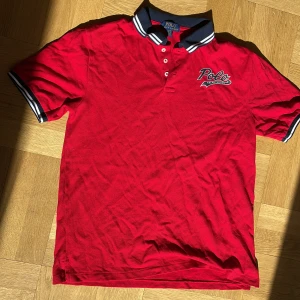 Ralph Lauren Piké - Tjena, min röda Ralph Lauren Piké ska nu säljas. Anledningen är för att jag inte använder den. Den är aldrig använd. Den ser helt ny ut. Inga fläckar. Inga märken. Den är perfekt för sommaren, den är inte för varm eller kall. 