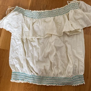 Resorblus - Kan bäras off shoulder och ovanför axlarna. Jättemjuk och skön. Gräddvit med turkosa stygn.