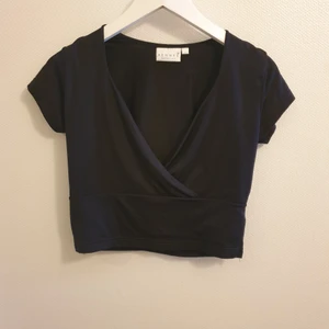 Svart croppad topp - Svart stretchig croppad topp från H&M, djupt v-ringad, stl L men inte större än M skulle jag säga 