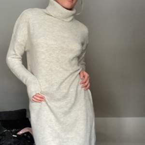 Ljusbeige/ljusgrå långärmad stickad klänning med polokrage från Chiquelle, storlek One size.