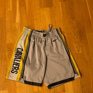 NBA Shorts - Cleveland cavaliers tema - Ett par Basketsskor av Nike / NBA med basketlaget Cleveland cavaliers som motiv. De är väldigt sköna och har fickor för tillhörigheter. De har även ett snören för att spänna åt vid behov.