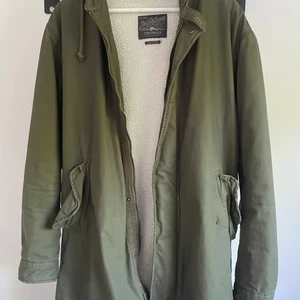 Grön parkas med teddytyg - Mycket använd parkas från jack and jones, har ett hål i en av fickorna och lite slitage i teddy insidan av jackan. Utöver det bra skick.