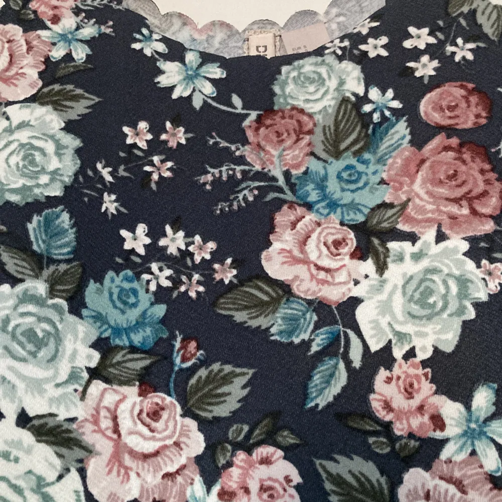 Ett blommigt blågrått linne från H&M Divided. Det är stretchigt material. Storlek S. Använt några gånger, men ser nytt ut. 40kr. . Toppar.