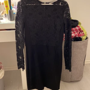 Svart festklänning  - En svart klänning i tjockt material från tiger of sweden med ordinariepris 2 000kr. Oanvänd, jättefin med spets i ärmarna och dragkedja hela vägen baktill. Säljer för 350kr+frakt. 