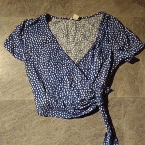 Osymmetrisk tröja - Osymmetrisk blå tröja med prickar och korsad framsida. Fint skick, använt vid ett tillfälle. Strlk XS, men tror även S skulle funka