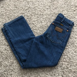 Wrangler Jeans - Säljer dessa super fina wrangler jeans då de tyvärr inte passar mig. Måttet rätt över på midjan är 34cm, innerbens längden är ca 70cm. Passar den som har ca storlek 32. Lägg gärna pris förslag 💕