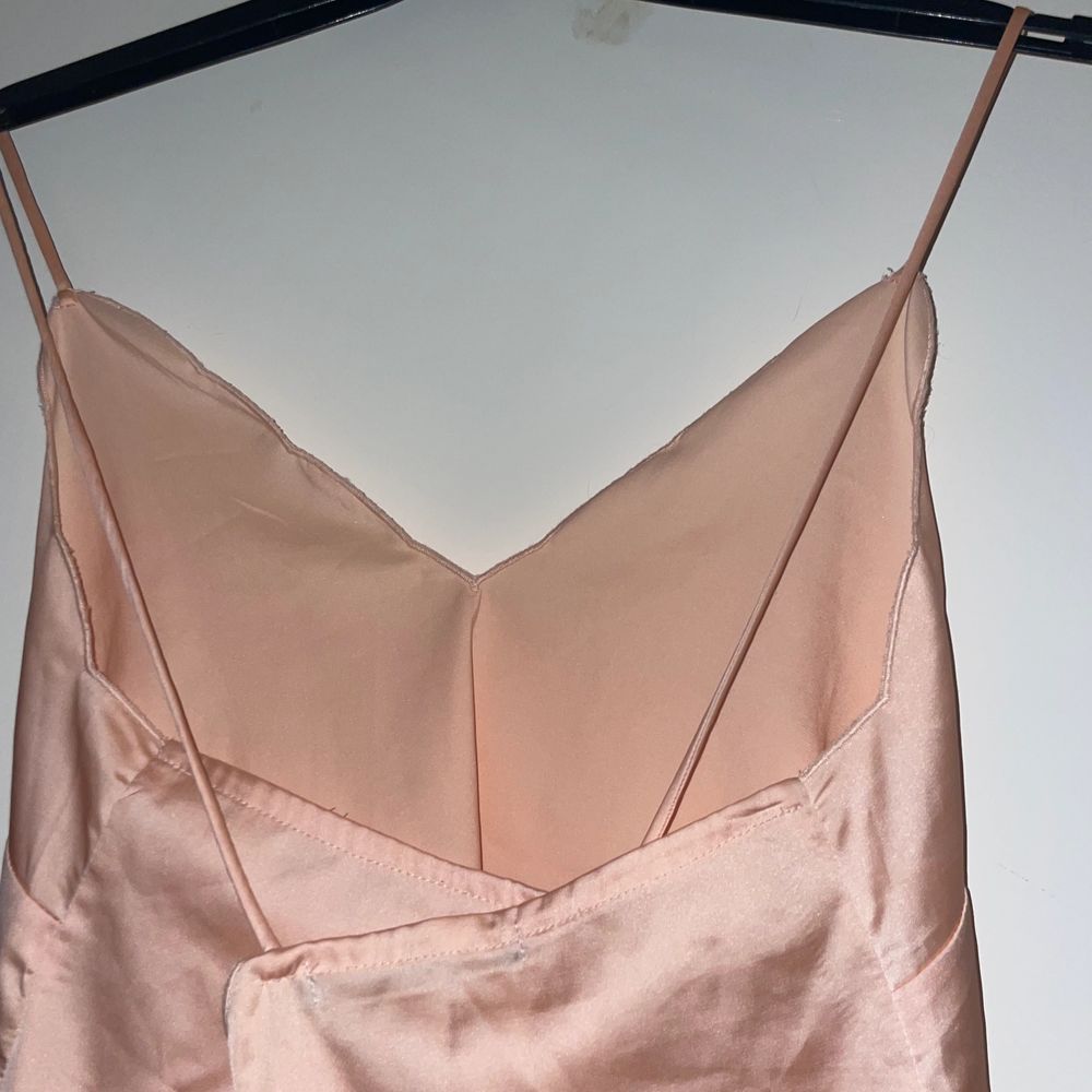 en fint rosa siden linne med kors i ryggen, tycker den är jättefin men inte kommit till användning. hittar inte storleken men skulle gissa på en xs/s. Toppar.