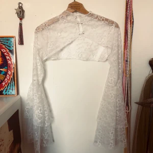 Spets topp - Spets topp jag sytt av material köpt på secondhand! Så snygg att ha under klänningar, linnen osv för att göra outfiten mer intressant! Går precis över bysten! Trumpetärmar som ger en 70-tals vibe och hög krage :)