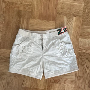 Cargo Shorts - Cargoshorts med coola bakfickor och detalj på sidan!! Midjan och nedre kanten är stretchig. Står storlek M men passar mig med xs-s💓fråga för bilder på mm.